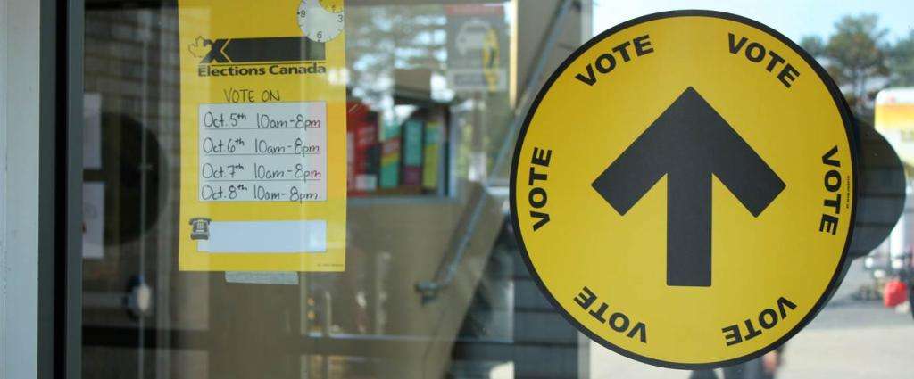 Two voting information stickers on a window glass. 