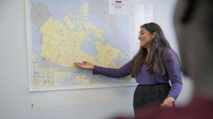 A teacher points at a large map of Canada.