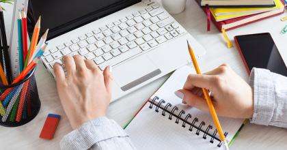 A person's hands at a computer desk