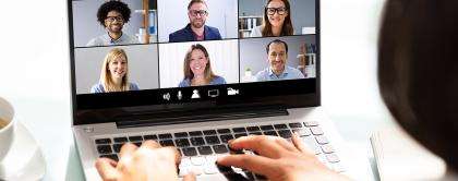 A video conference is displayed on a laptop. Six participants are present. 