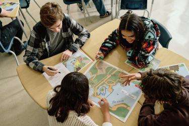 In a classroom, a group of students work together on a learning activity. 