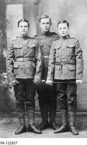 Black and white photograph of three young soldiers in uniform.  