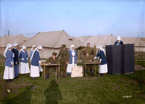 Photograph of a group of female military nurses lining up and voting outside during the First World War.