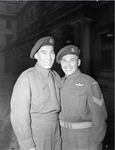 Black and white photo of Sergeant Tommy Prince (on the right), 1st Canadian Parachute Battalion, with his brother, Private Morris Prince, at an investiture at Buckingham Palace.