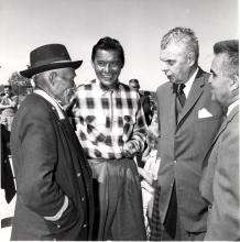 VRTT_FNP_1960_EN Black and white photo of John Diefenbaker with Chief Jimmy Bruneau of Rae, Chief Joe Sangris, and the Mayor of Yellowknife, Northwest Territories, in discussion.